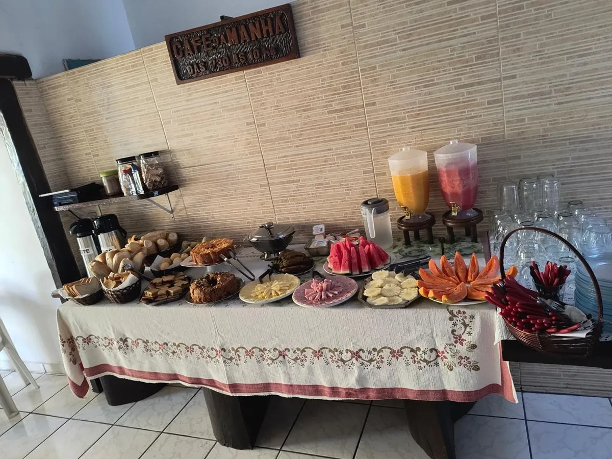 Mesa do café da manhã com pães, frutas e sucos