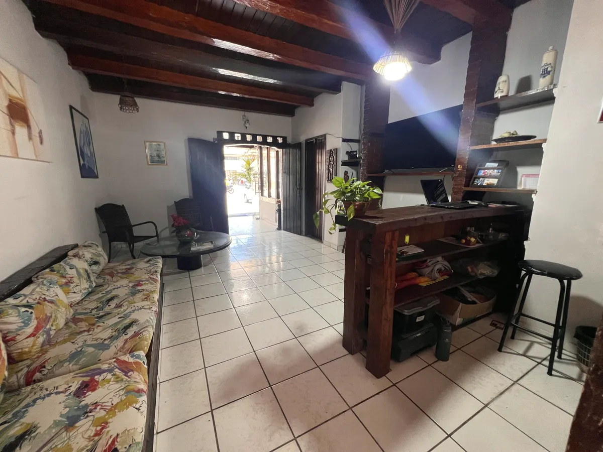 Sala de estar da recepção com sofá, teto de madeira e balcão