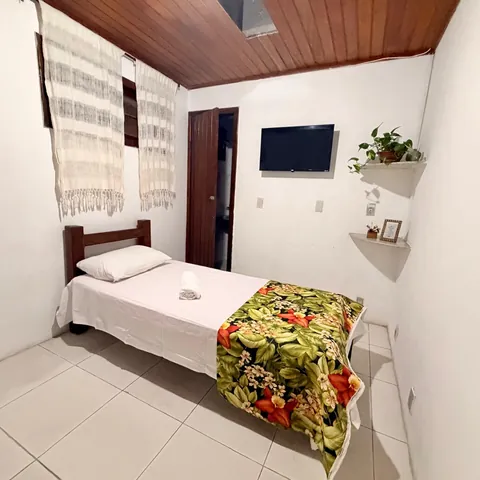 Quarto com cama de solteiro e TV